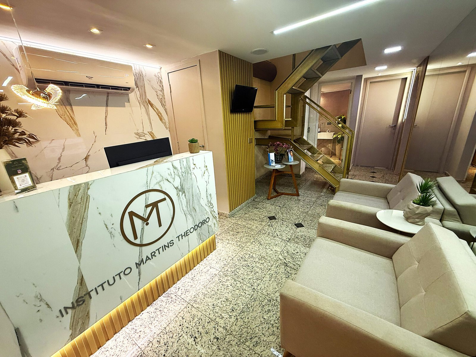 Recepção do Instituto Martins Theodoro, com balcão de mármore e monograma da marca